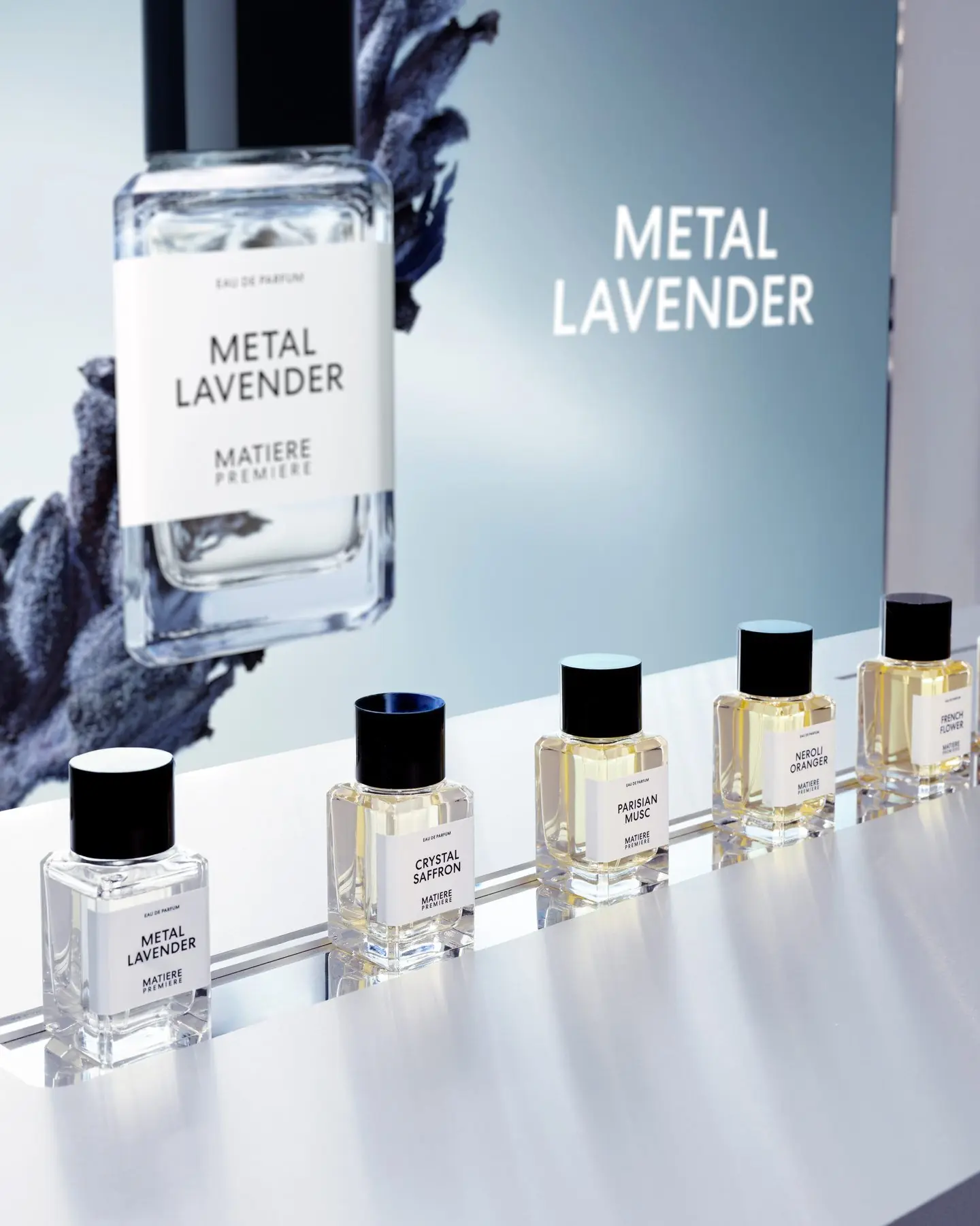 Table d'essai Matiere Premiere chez Saks, flacons alignés devant l'écran Metal Lavender