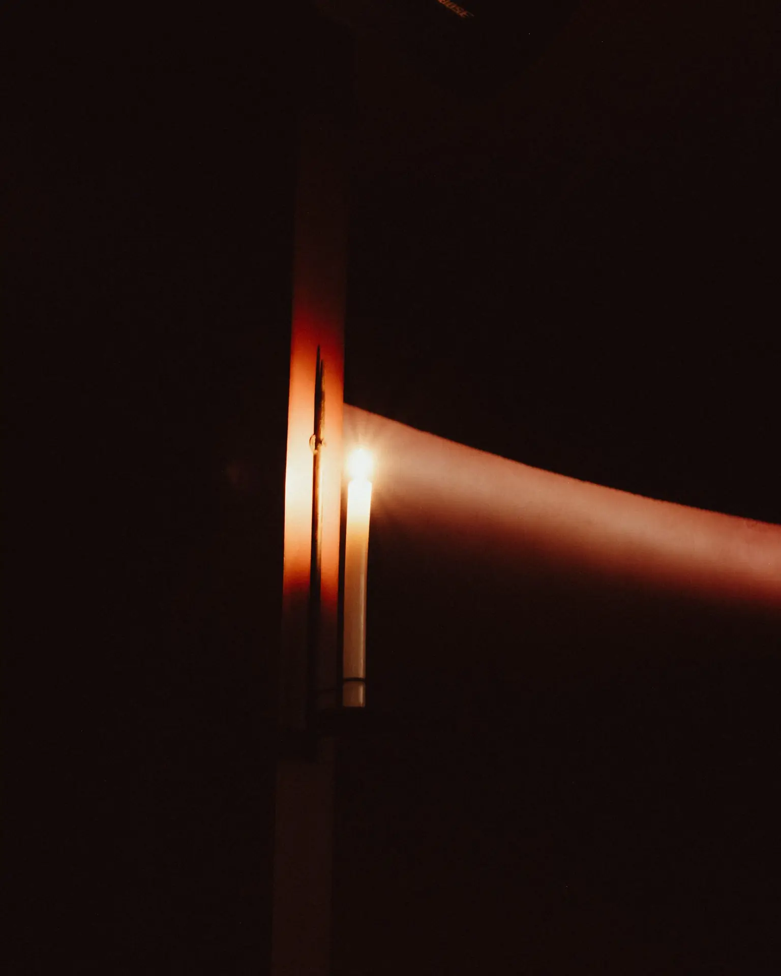 Flamme de bougie en gros plan, lumière chaude